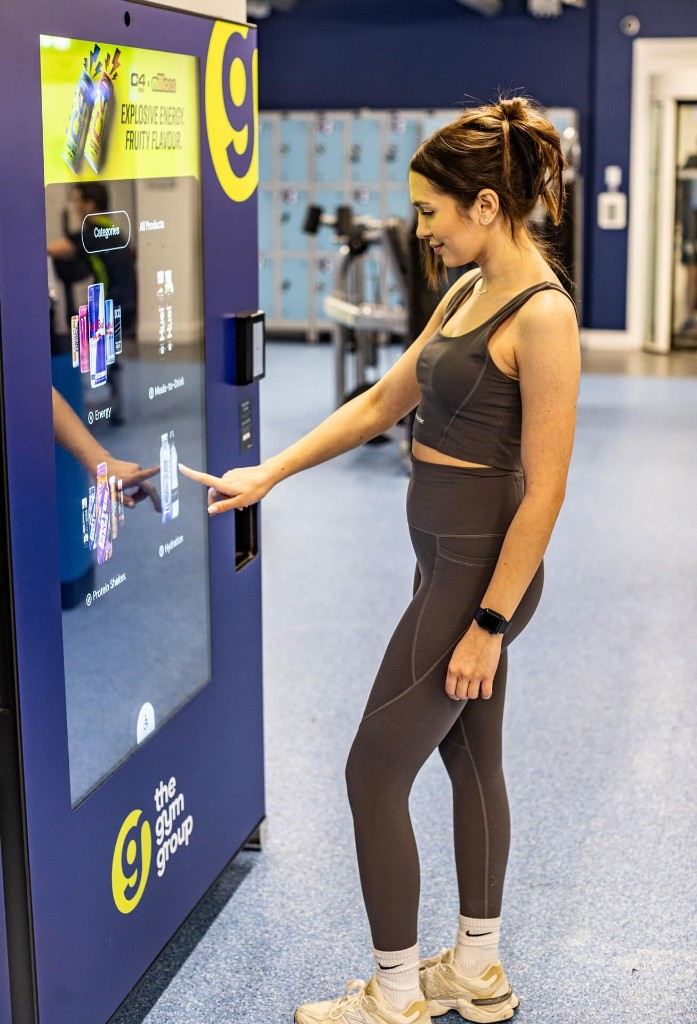 Gym member tapping a Bright.Blue screen with Red Bull in Energy